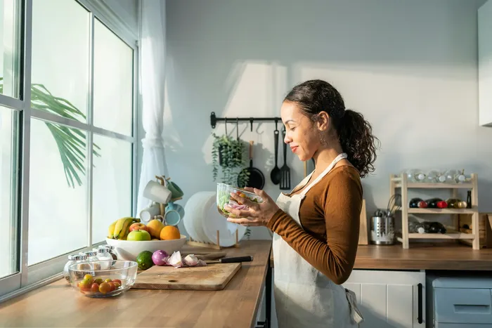 A woman journaling at a kitchen table with morning light