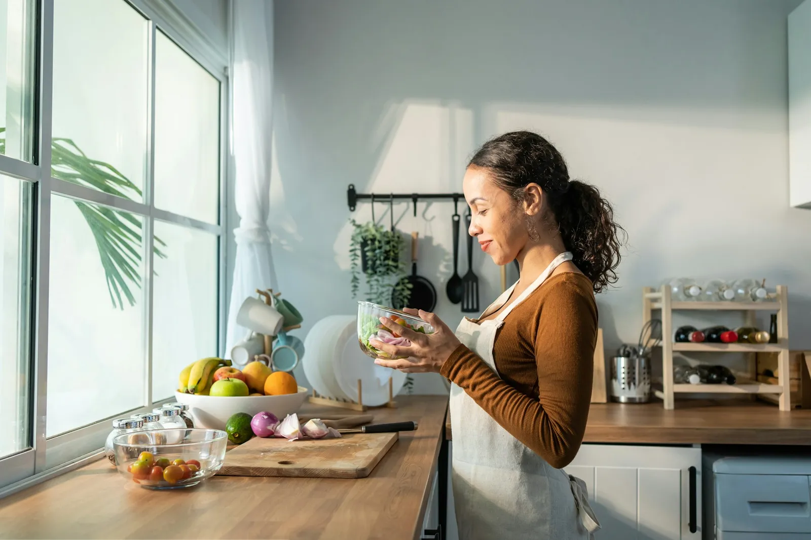 A woman journaling at a kitchen table with morning light