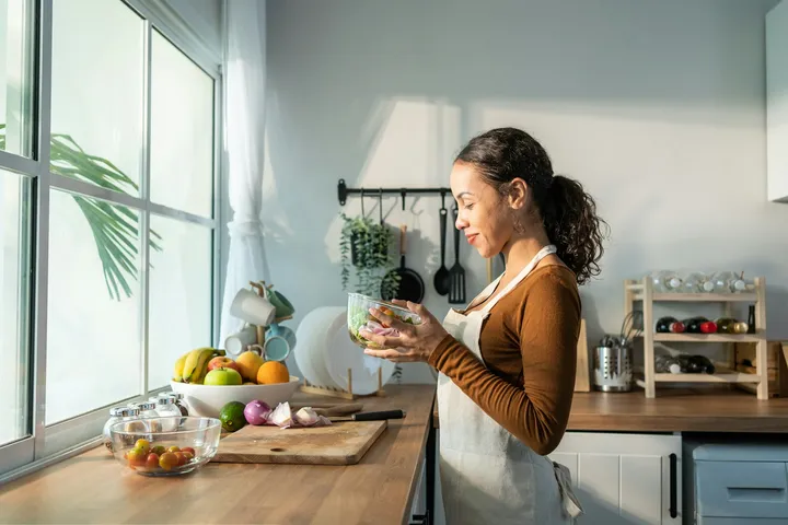 Woman reading at her kitchen bench, soft afternoon light