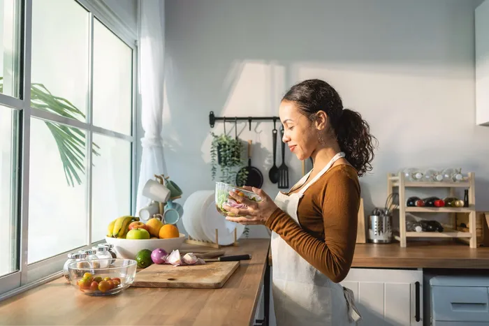 A woman journaling at a kitchen table with morning light