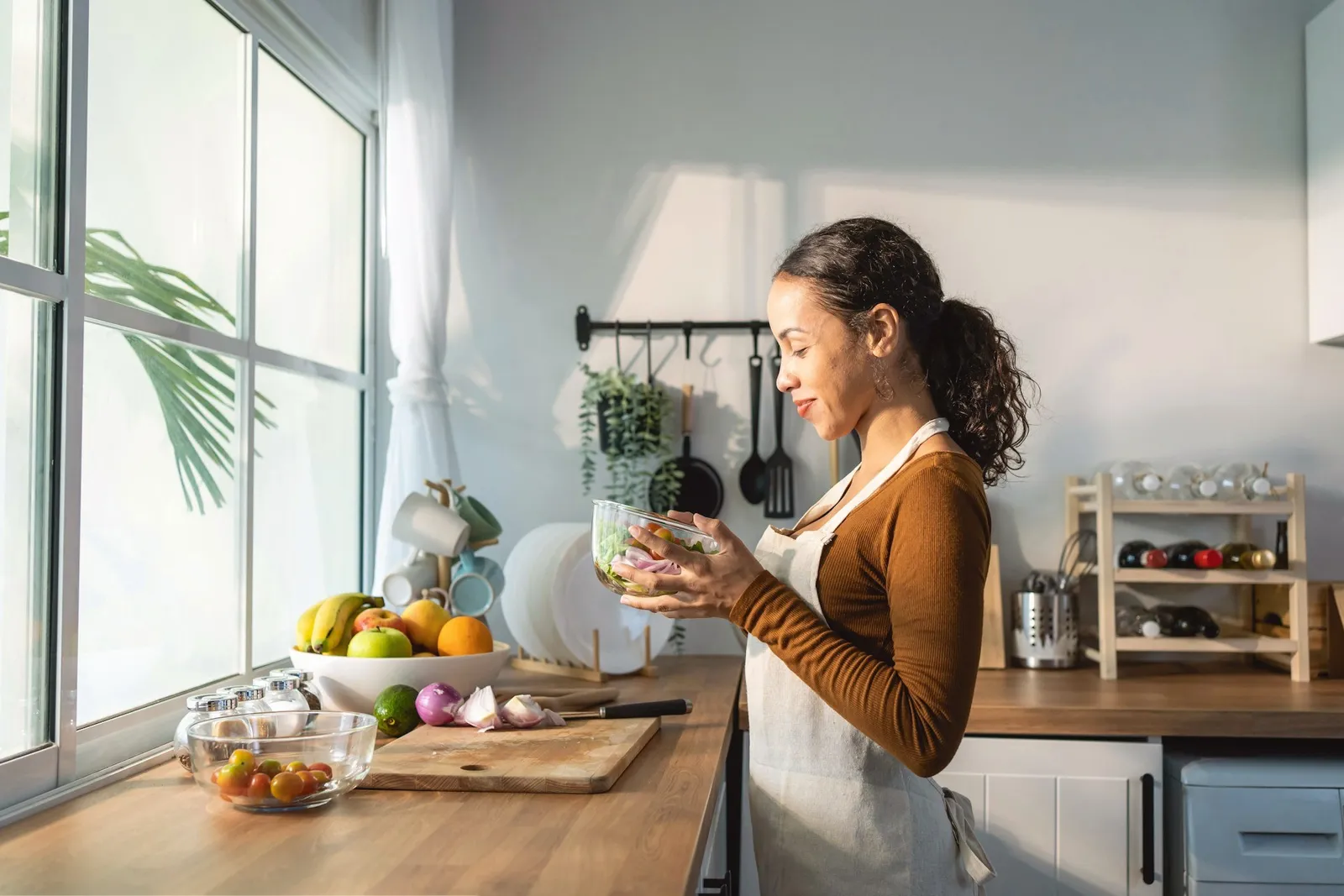 A woman journaling at a kitchen table with morning light
